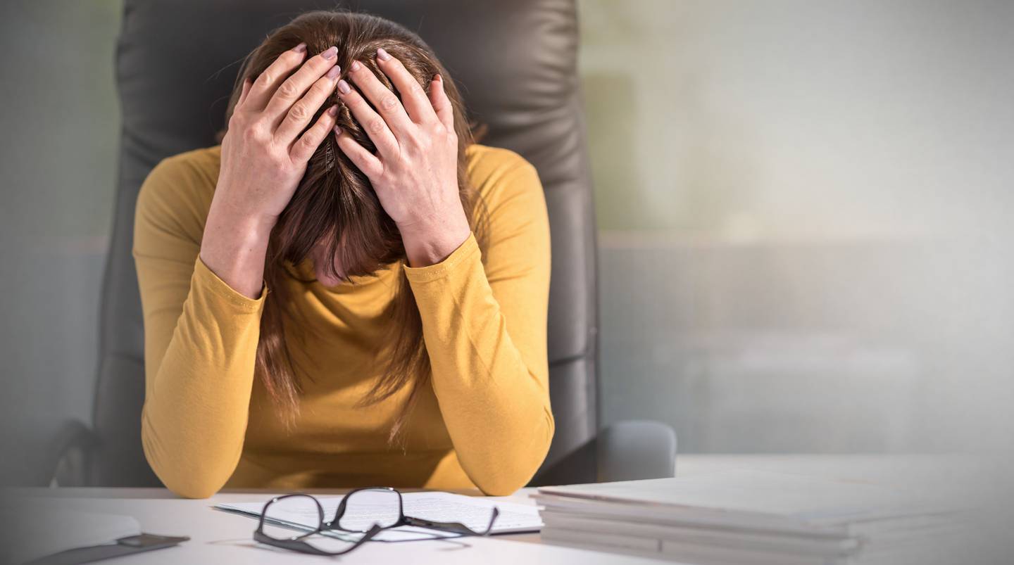 woman at desk office upset stock